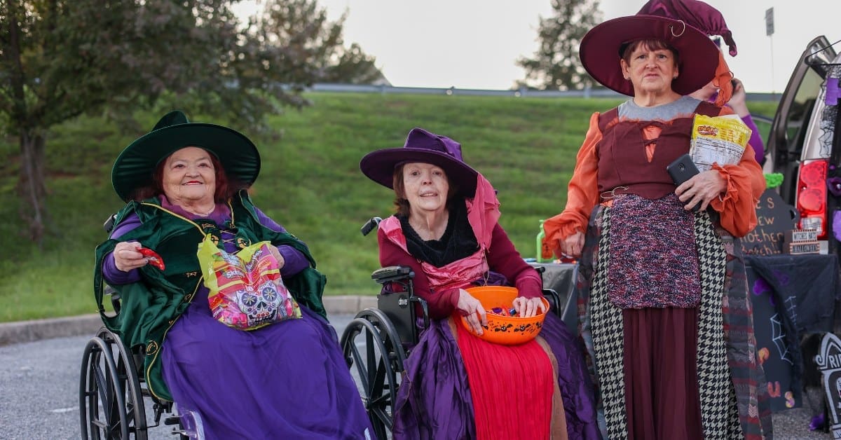 Three TLC individuals wear witch costumes during Halloween.