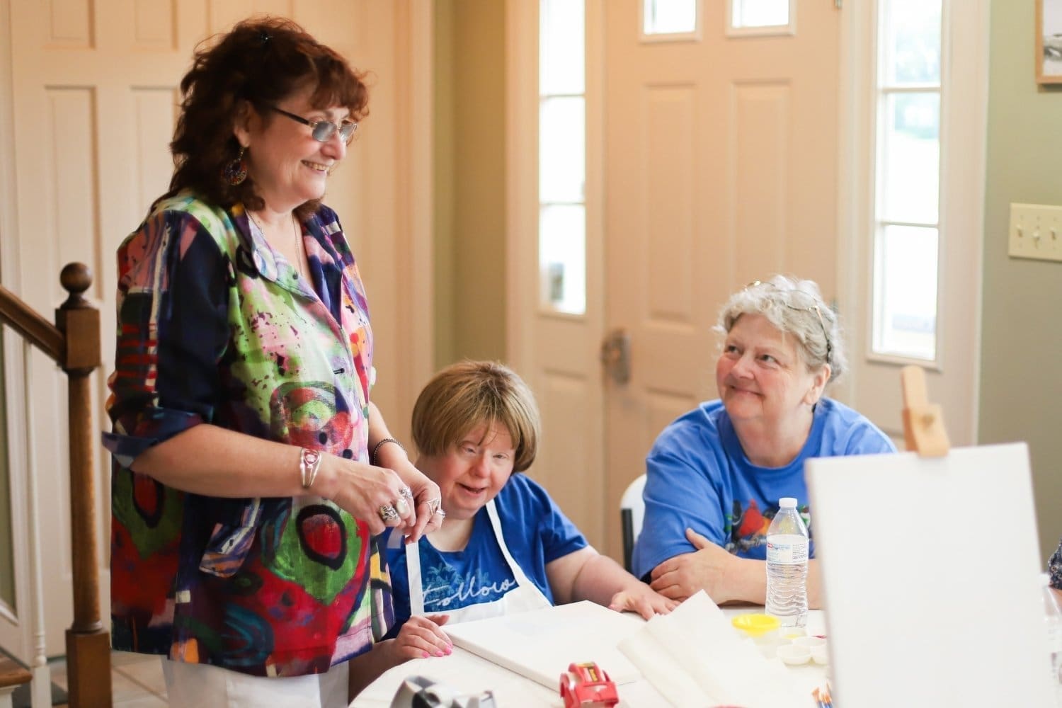 A TLC DSP looks over two TLC individuals during a paint night session.