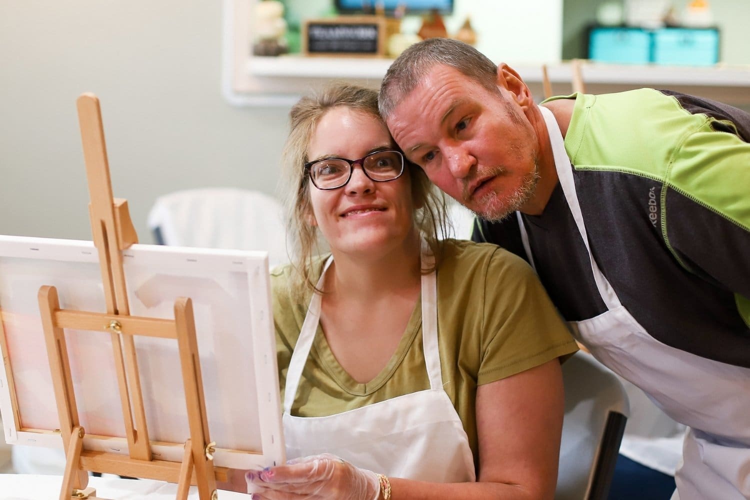 Two TLC individuals pose for a photo during a paint night session.