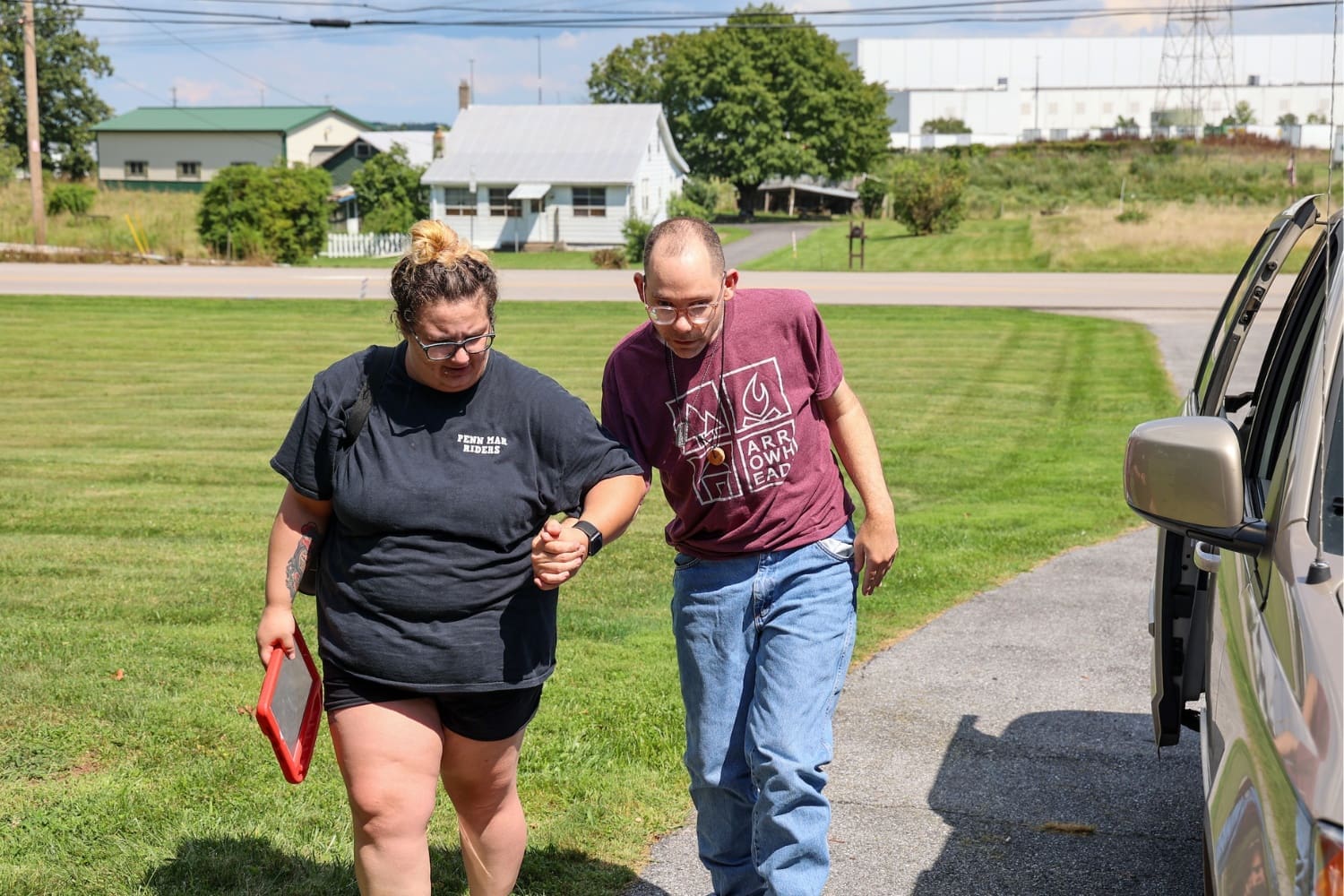 A TLC Direct Support Professional walks an individual to his residence.
