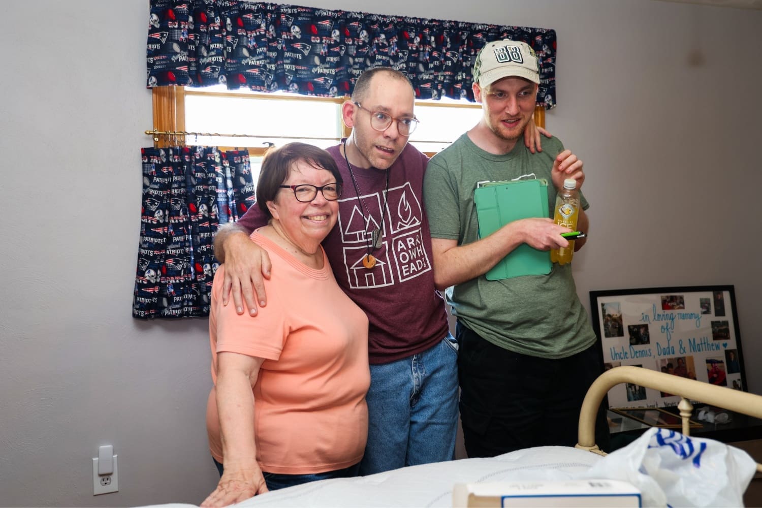 A TLC Direct Support Professional poses with two individuals in their residence.