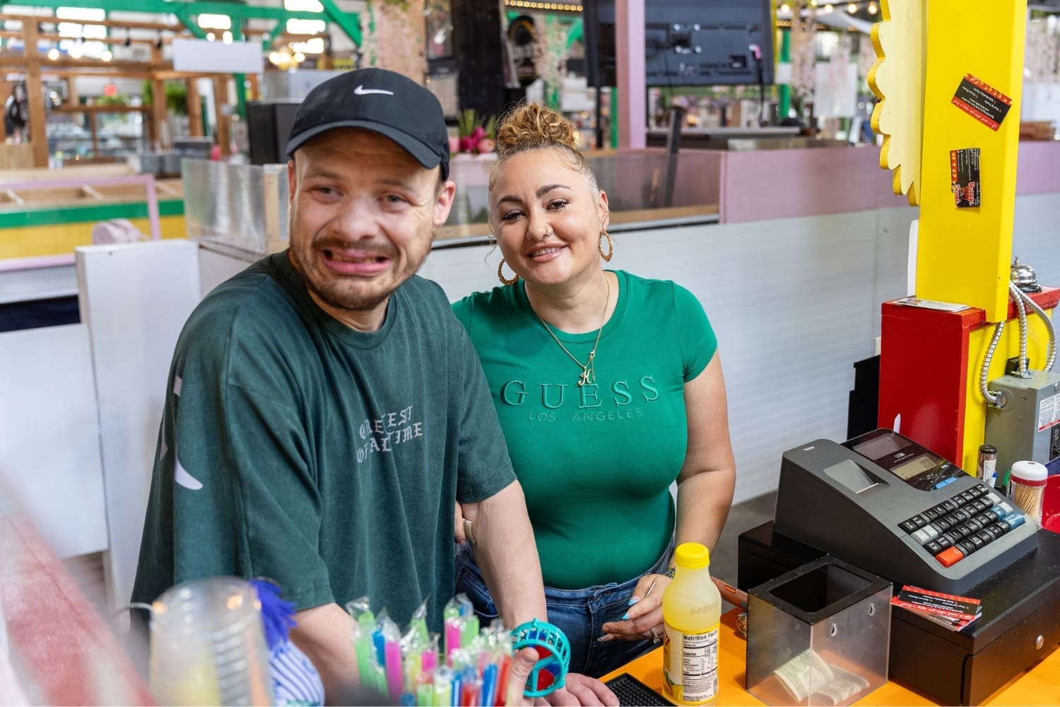 Ryan and Direct Support Professional Kayla Powell smile together at a counter inside Central Market York during one of their regular community outings, helping Ryan build confidence and independence.