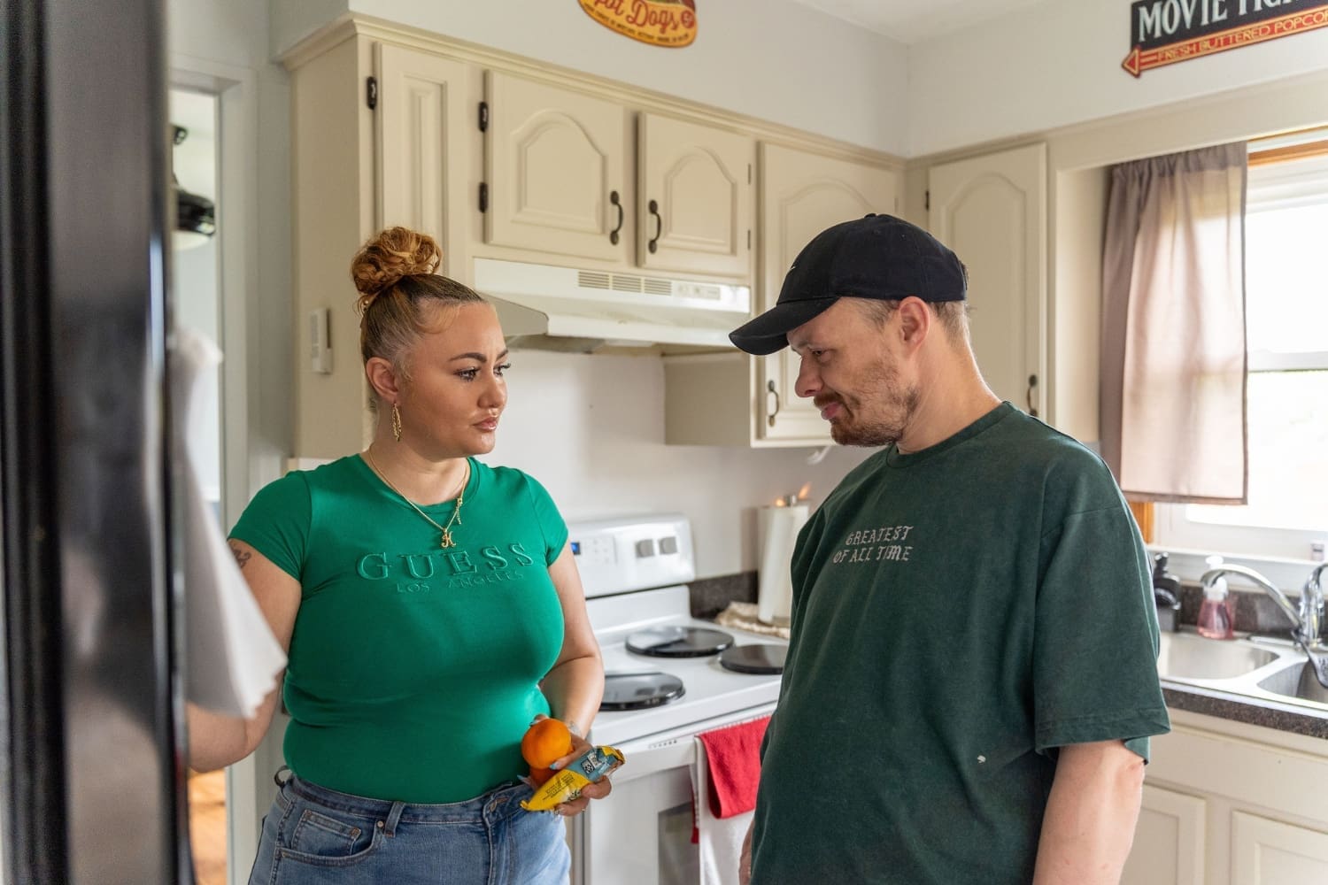 Direct Support Professional Kayla Powell talks with Ryan in the kitchen of his TLC home while helping him with his daily routine and encouraging independence.